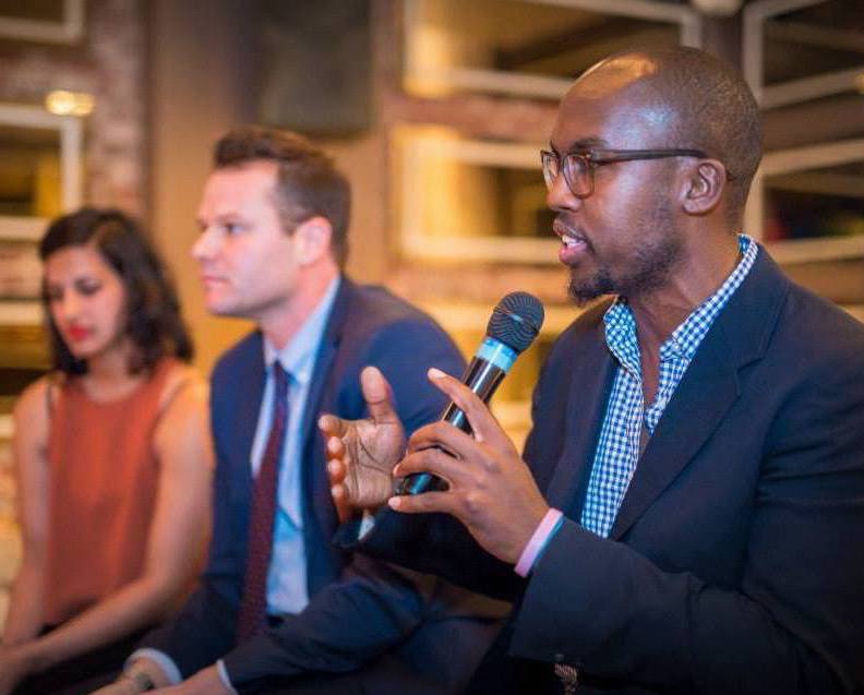 A panelist talking with a microphone.